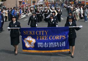 パレード行進中の女性消防団員の写真
